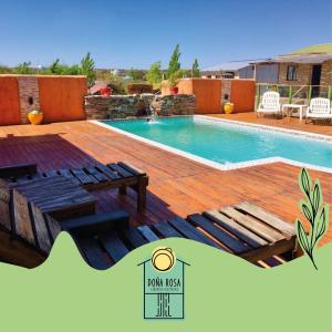 una piscina con terraza de madera y piscina en DOÑA ROSA CABAÑAS en Luján de Cuyo