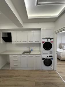 a kitchen with white cabinets and a sink and a stove at Royal Villa in Forest in Dosemealti