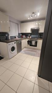 a kitchen with a washing machine and a washer at 3 bedroom detached by the sea in Prestatyn