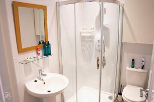 a bathroom with a shower and a sink and a toilet at Portrush by the Sea - 3 West Beach in Portrush