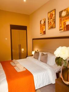 1 dormitorio con 1 cama blanca grande y un jarrón de flores en Sliema Aqualuna Premium Apartment en Sliema