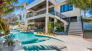 a house with a swimming pool in front of a house at Shaker of Salt in Siesta Key