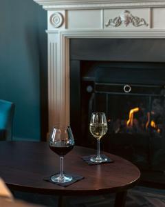 倫敦的住宿－倫敦希爾頓逸林酒店- 港口河畔，壁炉前的桌子上放着两杯葡萄酒