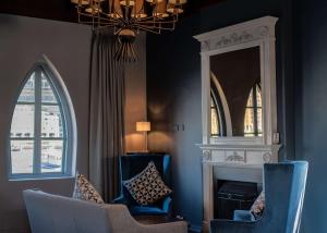 a living room with blue chairs and a mirror at DoubleTree by Hilton London – Docklands Riverside in London