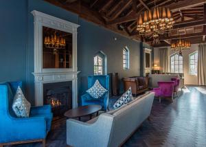 sala de estar con sillas azules y chimenea en DoubleTree by Hilton London – Docklands Riverside, en Londres