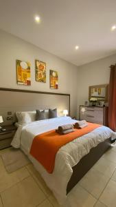 1 dormitorio con 1 cama grande con manta naranja en Sliema Aqualuna Premium Apartment en Sliema