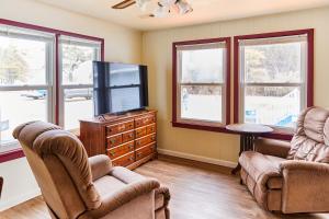 a living room with two chairs and a flat screen tv at Beach House @ The Reef in Chincoteague