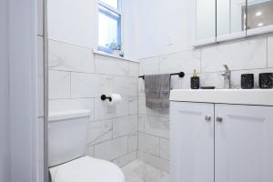 a white bathroom with a toilet and a sink at 7-2 2BR 1Bath in Prime Park Slope in Brooklyn