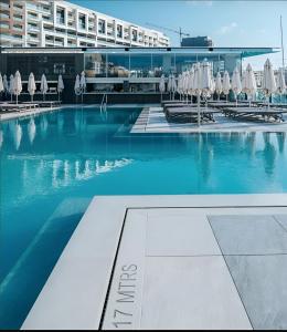 una piscina con sillas y sombrillas en un hotel en Sliema Aqualuna Premium Apartment en Sliema