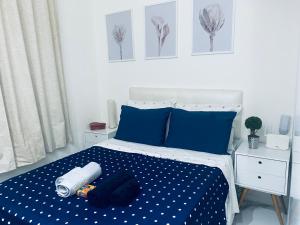 um quarto com uma cama com lençóis azuis e almofadas azuis em Copacabana beach- perto da praia no Rio de Janeiro