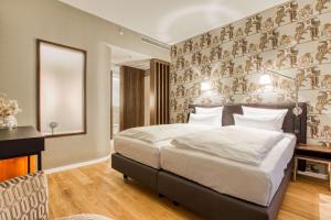a bedroom with a large bed and a mirror at Parkhotel Heilbronn in Heilbronn