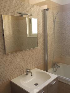 y baño con lavabo, espejo y bañera. en Sliema Aqualuna Premium Apartment en Sliema