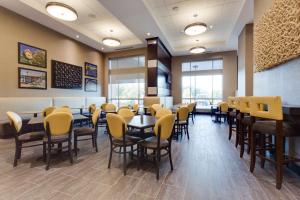 un comedor con mesas y sillas amarillas en Drury Inn & Suites Dallas Frisco, en Frisco