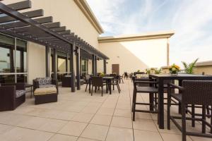 un patio al aire libre con mesas, sillas y ventanas en Drury Inn & Suites Dallas Frisco, en Frisco