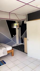 a room with a bed and a refrigerator in it at Ouest Nelis Lodge in Saint-Laurent du Maroni