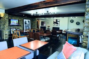 um restaurante com mesas e cadeiras e um bar em The Addison Hotel SureStay Collection by Best Western em Addison