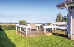 a deck with two benches and a table and chairs at Holiday Home Bellevue Iii in Skovby