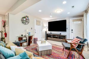 a living room with a couch and a flat screen tv at Pet-Friendly Silver Spring Condo with Yard! in Silver Spring