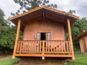 a small house with a porch and a deck at Chalés Roma in Santo Antônio do Pinhal