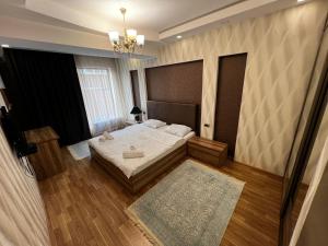 - une chambre avec un grand lit et un lustre dans l'établissement Park Azure 1147, à Baku