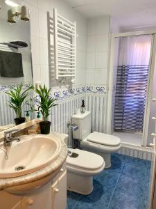 a white bathroom with a toilet and a sink at Habitación My Home Alicante in Alicante