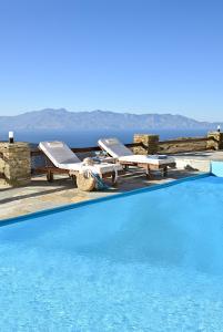 a swimming pool with two lounge chairs and a table at the nest in Andros