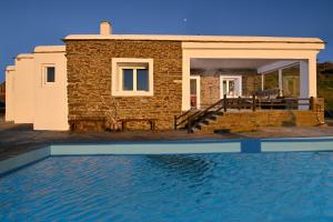 a stone house with a pool in front of it at the nest in Andros