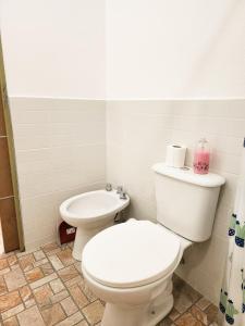 a white bathroom with a toilet and a sink at Departamento DORREGO, A estrenar in Guaymallen