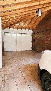 a garage with four white garage doors and a wooden ceiling at Departamento DORREGO, A estrenar in Guaymallen