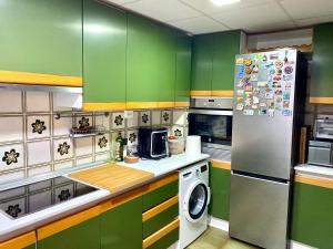 a kitchen with green cabinets and a refrigerator at Habitación My Home Alicante in Alicante