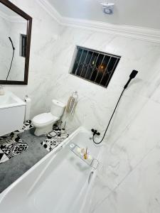baño blanco con bañera y aseo en Mayberry Heights, en Alberton