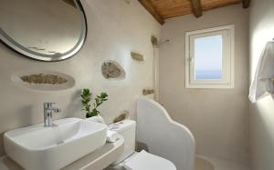 a bathroom with a sink and a toilet and a mirror at the nest in Andros