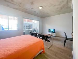 Charming Studio in the Heart of La Boca - Caminito في بوينس آيرس: غرفة نوم بسرير وطاولة ومكتب