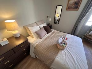 Un dormitorio con una cama con una lámpara y una cesta. en Pézenas Centre - Charme village - Plage 15 mn en Pézenas