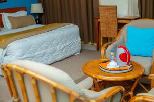 Schlafzimmer mit einem Bett, einem Tisch und Stühlen in der Unterkunft Hotel Le Marly in Abidjan