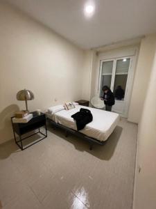 una persona parada en un dormitorio con una cama y una ventana en casa huéspedes tadeo gran via, en Madrid