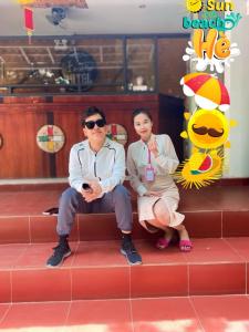 two people sitting on a bench in a restaurant at Konklor Hotel in Kon Tum