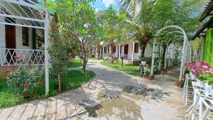 um jardim com palmeiras e uma casa em Konklor Hotel em Kon Tum