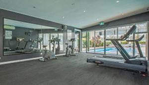 a gym with several tread machines and a swimming pool at The Parkmore Hotel in Melbourne