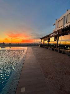 a building next to a swimming pool at sunset at The blue pearl-Sensational beach apartment in Aourir in Agadir