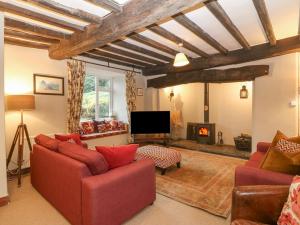 a living room with red furniture and a fireplace at Cwm in Betws-y-coed