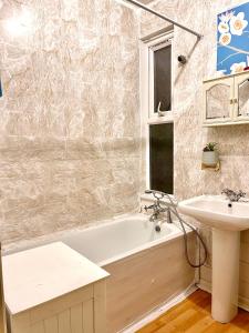 a bathroom with a white tub and a sink at Comfy Double bedroom with a Private Toilet in London