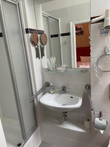 a small bathroom with a sink and a shower at Hotel Astrid am Kurfürstendamm in Berlin