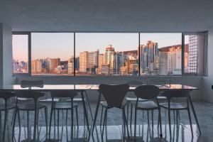 a dining room with a view of a city skyline at The Wave Pension in Busan