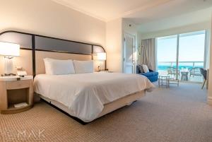 a bedroom with a large bed and a living room at FontaineBleau Resort High Floor w Ocean Views in Miami Beach