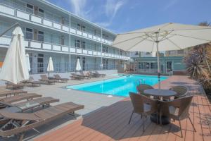 a hotel with a pool and a table with an umbrella at The Parkmore Hotel in Melbourne