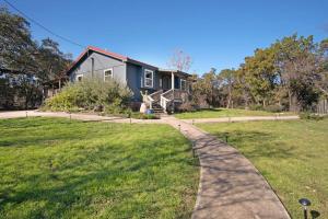 a house with a walkway in front of a yard at A Special Retreat on a Mini-Farm -- in SMTX in San Marcos