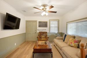 - un salon avec un canapé et un ventilateur de plafond dans l'établissement A Family Farmhouse in the Oak Groves of SMTX, à San Marcos