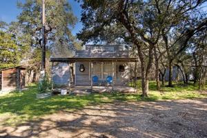 a small house with two blue chairs in the yard at A Quaint Countryside Tiny Home - Outhouse & Outdoor Shower Included in San Marcos