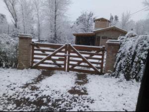 a wooden gate in a yard with snow on it at CASA CAMPO in Villa General Belgrano